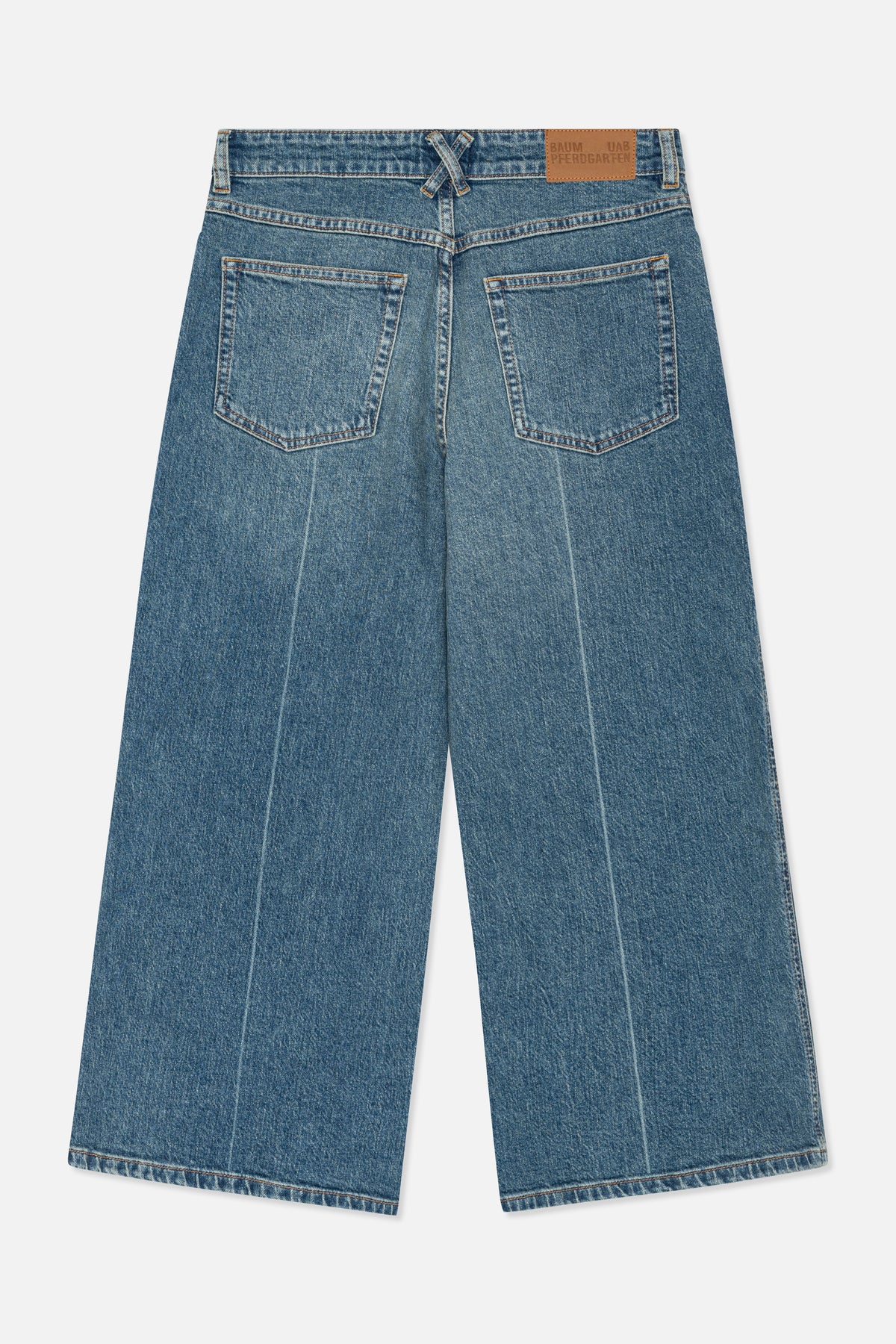 Nahaufnahme der Rückseite einer blau gewaschenen denim-Jeans mit zwei aufgesetzten Taschen, orangefarbener Steppnaht und einem beigefarbenen Markenpatch am Bund.