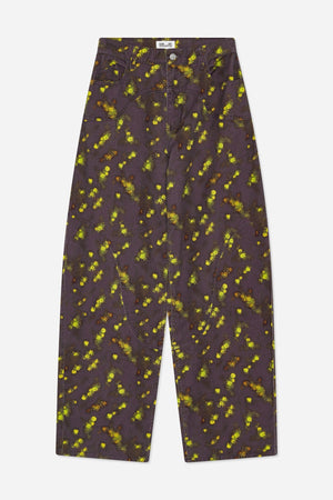 Vorderansicht einer Wide-Leg-Jeans mit dunkelpflaumenfarbenem Grund, verstreutem gelb-grünem und rostfarbenem Blumenmuster sowie geschwungenen vorderen Nähten und Taschen.